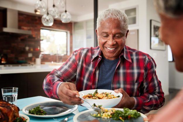 3 Dishes to Cook For Seniors man in plaid shirt serving food for seniors