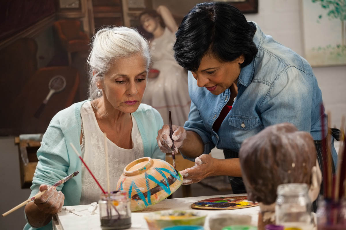 Senior paints bowl as she learns how to make arts and crafts